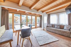 a living room with a table and a couch at Hotel Salzburg in Saalbach-Hinterglemm