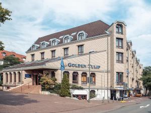 a large building with a clock on the front of it at Golden Tulip Bielefeld City in Bielefeld