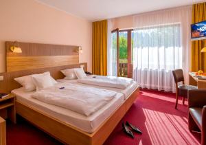 ein Schlafzimmer mit einem großen Bett und einem großen Fenster in der Unterkunft Gasthof & Landhotel Ohrnbachtal in Weilbach