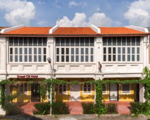 a large white building with an orange roof at Sweet Cili Boutique Hotel in George Town