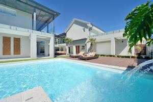 a woman sitting on a chair in front of a house at Grand Blue D in Cape Town