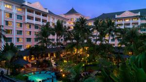 a view of a hotel with palm trees and a courtyard at Melia Purosani Yogyakarta in Yogyakarta