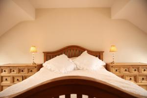 a bedroom with a bed with two dressers and two lamps at Cuilcagh Luxury Apartment in Enniskillen