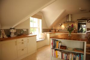 a kitchen with a book shelf filled with books at Cuilcagh Luxury Apartment in Enniskillen