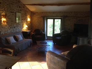 a living room with a couch and chairs and a tv at Gîte Le Gré in Chantemerle-lès-Grignan