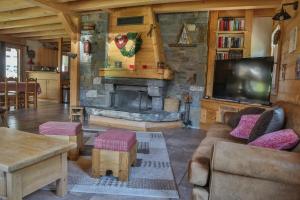 a living room with a stone fireplace and a tv at Bed and Breakfast Chalet Manava in Morzine