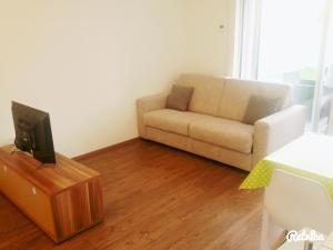 a living room with a couch and a tv at Apartment Bruneck Central in Brunico