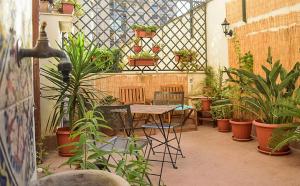 a patio with a table and chairs and potted plants at il lapino in Palermo