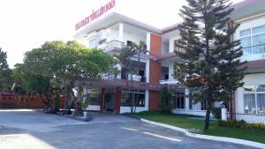 フエにあるSong Huong Hue Hotelの前に木々がある大きな白い建物