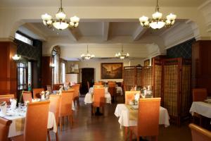 a dining room with tables and chairs and chandeliers at Hotel Barbakan in Trnava
