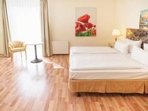 ein Schlafzimmer mit einem Bett und einem Tisch darin in der Unterkunft Hotel am Schloß Köpenick by Golden Tulip in Berlin