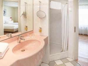 a bathroom with a sink and a shower at Hotel am Schloß Köpenick by Golden Tulip in Berlin