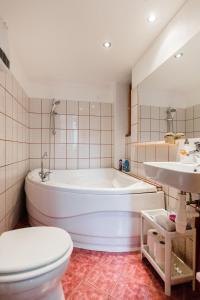 a bathroom with a tub and a toilet and a sink at Kazinczy 10 Apartment in Budapest