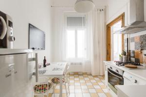 a white kitchen with a table and a sink at Kazinczy 10 Apartment in Budapest