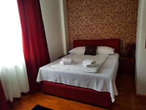 a bedroom with a bed with two towels on it at Hotel BOB in Sarajevo