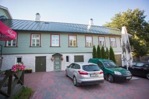 two cars parked in a parking lot in front of a house at Katariina Guesthouse in Rakvere