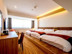 a hotel room with two beds and a desk and a desk at TKP Lectore Atami Momoyama in Atami