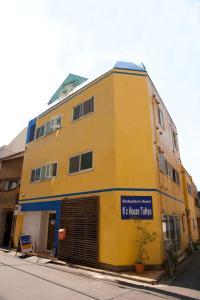a yellow building on the side of a street at K's House Tokyo - Travelers Hostel in Tokyo