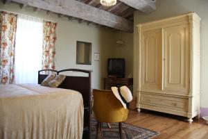 1 dormitorio con 1 cama, 1 silla y TV en Poggio Dei Prugnoli en Tavoleto