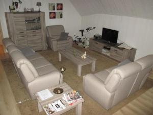 un soggiorno con divani e TV di Vakantieverblijf-Beestenboel a Retie