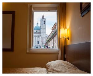 a bedroom with a window with a view of a building at Residenza dei Capitani in Ascoli Piceno