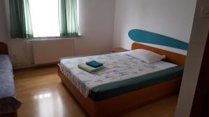 een kleine slaapkamer met een bed met een blauw hoofdeinde bij Guesthouse Koprivec in Ljubljana