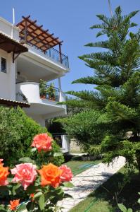 una palmera al lado de un edificio con flores en Efi & Zoi Apartments, en Sivota