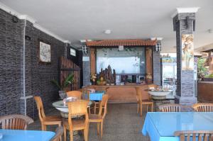 a restaurant with tables and chairs and a dining room at Padangbai Beach Homestay in Padangbai