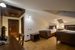 een hotelkamer met 2 bedden en een bureau. bij Hotel Barleti in Prizren