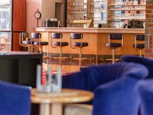 a restaurant with blue chairs and a counter at Hotel Dänischer Hof Altenholz by Tulip Inn in Altenholz