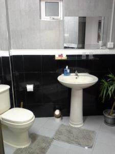 a bathroom with a toilet and a sink at Hello Guest House in Quatre Bornes