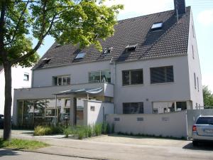 a white house with a black roof at Hotel Milú in Ludwigsburg