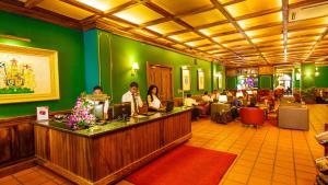 un vestíbulo de un hotel con gente sentada en un mostrador en The Steuart by Citrus, en Colombo