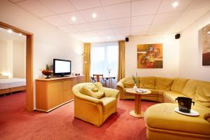 - un salon avec un canapé et une télévision dans l'établissement Hotel Dänischer Hof Altenholz by Tulip Inn, à Altenholz
