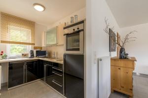 a kitchen with black and stainless steel appliances at AUSZEIT - Art & Design Ferienapartment in Bad Endbach