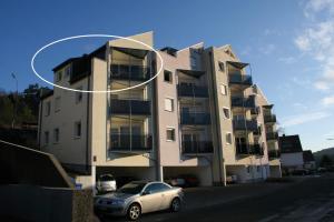 a building with a car parked in front of it at AUSZEIT - Art & Design Ferienapartment in Bad Endbach +4 photos