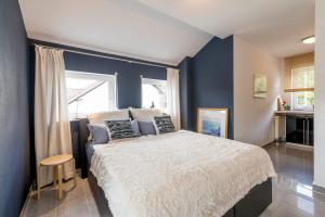 1 dormitorio con 1 cama grande y paredes azules en AUSZEIT - Art & Design Ferienapartment, en Bad Endbach