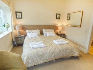 ein Schlafzimmer mit einem Bett mit zwei Handtüchern darauf in der Unterkunft Brooksides Byre Durham Country Cottage in Durham