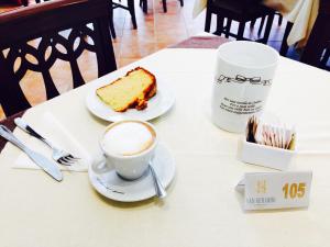 una tazza di caffè e una fetta di torta sul tavolo di Hotel San Berardo a Pescina