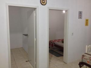 pasillo con 2 puertas y habitación con cama en Casa de praia, en Penha