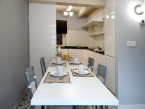 a kitchen with a long white table and chairs at Martina Lapiko in Ea