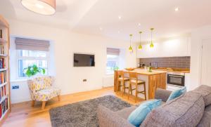 a living room with a couch and a kitchen at Little Heatherlea in Rothbury