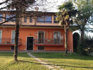 ペスキエーラ・デル・ガルダにあるAppartamento Valentinaのヤシの木が目の前にあるオレンジの家