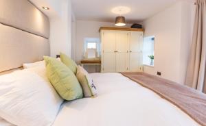 a bedroom with a large white bed with pillows at Little Heatherlea in Rothbury