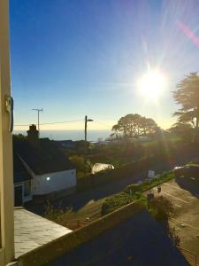 a view of the sun setting from a balcony at Waves - Duplex Apartment Stoke Fleming in Stoke Fleming