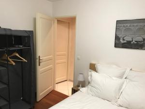 a bedroom with a white bed and a black cabinet at Appartements nimes in Nîmes