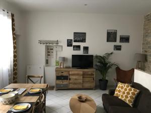 a living room with a table and a television at Appartements nimes in Nîmes