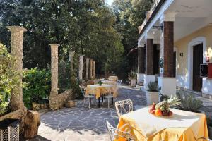 un patio con tavoli e sedie e un edificio di Albergo Ristorante Ferretti a Monteluco