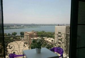 a balcony with a table and a view of a river at Luxury Nile Maadi Cairo Apartment in Cairo