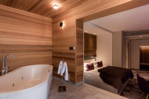 a bathroom with a tub and a bed in a room at Hotel Nox in Ljubljana